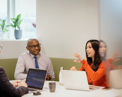 Groupe de trois employés en train de discuter autour d'une table